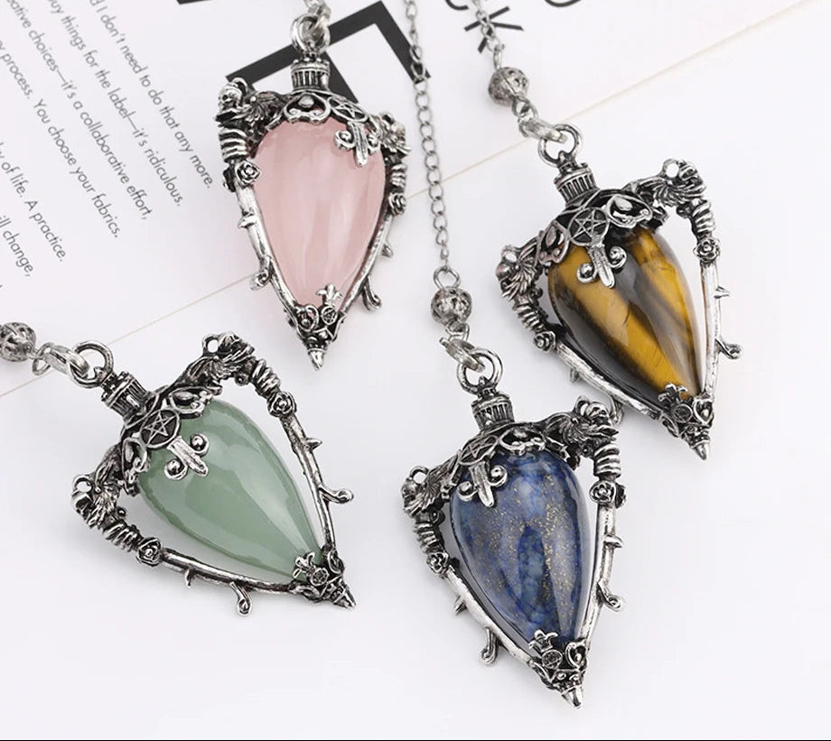 Four gemstone pendants on chains with a visible brand logo in the corner.