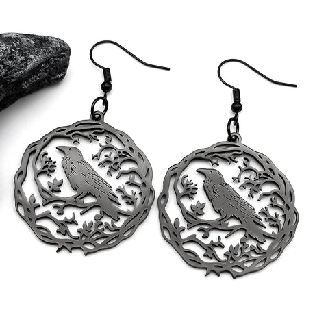 Pair of silver earrings with bird design on a white background