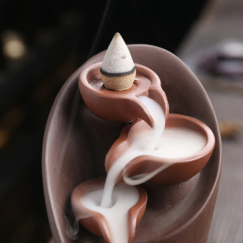 Ceramic incense burner with incense cones on a blurred background