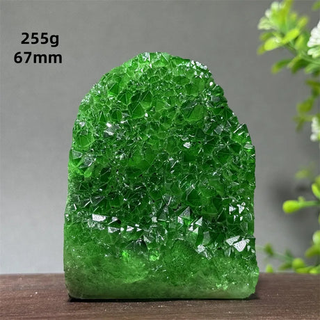 Green crystal rock on a wooden surface with a gray background