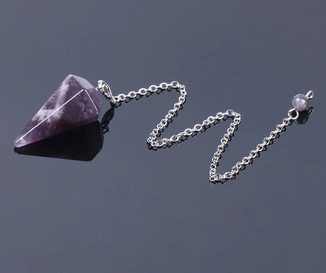Purple crystal pendant on a silver chain against a dark background