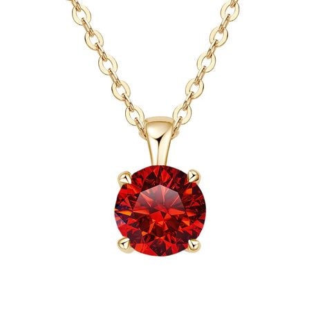 Gold necklace with a red gemstone pendant on a white background