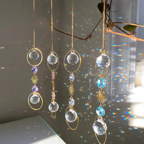 Crystal hanging decorations with gold chains on a reflective surface