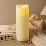 Lit candle in a decorative holder with soft fabric and a blurred 'etta' box in the background