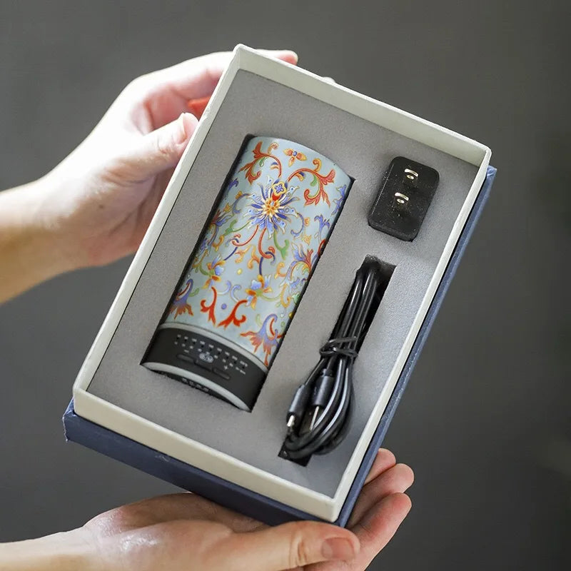 Product set with a floral-patterned device, power adapter, and cable in a box held by a person.