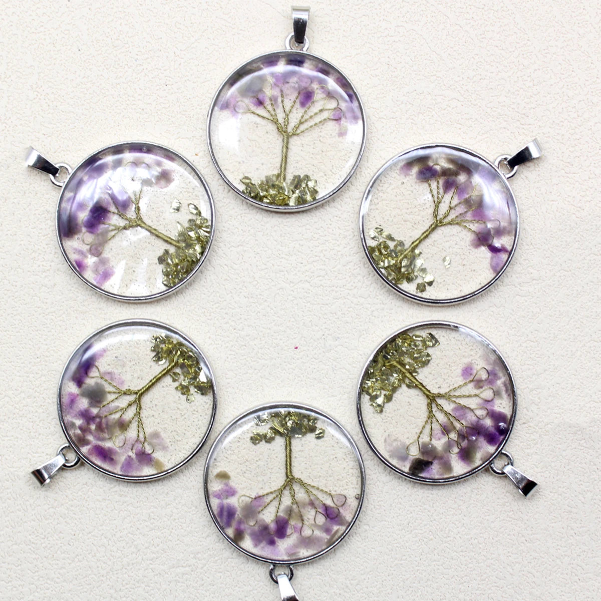 Six round pendants with floral designs on a light gray background
