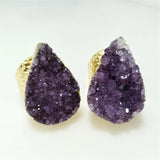 Purple crystal earrings with gold bases on a white background