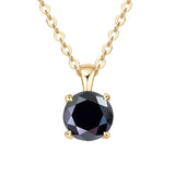 Gold necklace with a black gemstone pendant on a white background