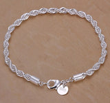 Silver braided bracelet with a clasp on a beige background