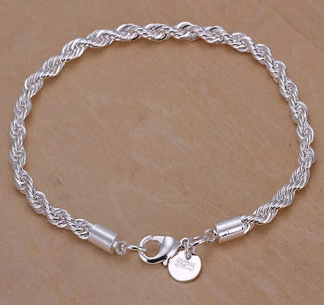 Silver braided bracelet with a clasp on a beige background