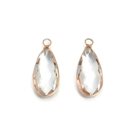 Teardrop-shaped crystal pendants with rose gold frames on a white background