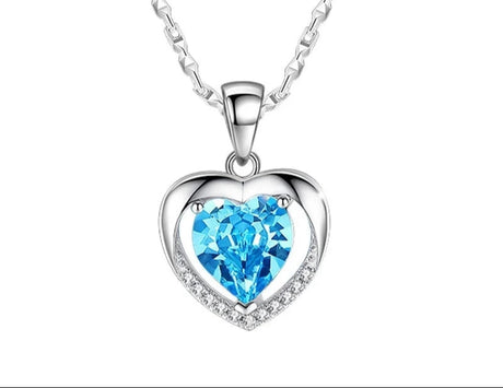 Heart-shaped pendant with blue gemstone on a white background, featuring the brand 'Giemi'.