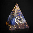 Pyramid-shaped crystal with gold and blue design on a black background