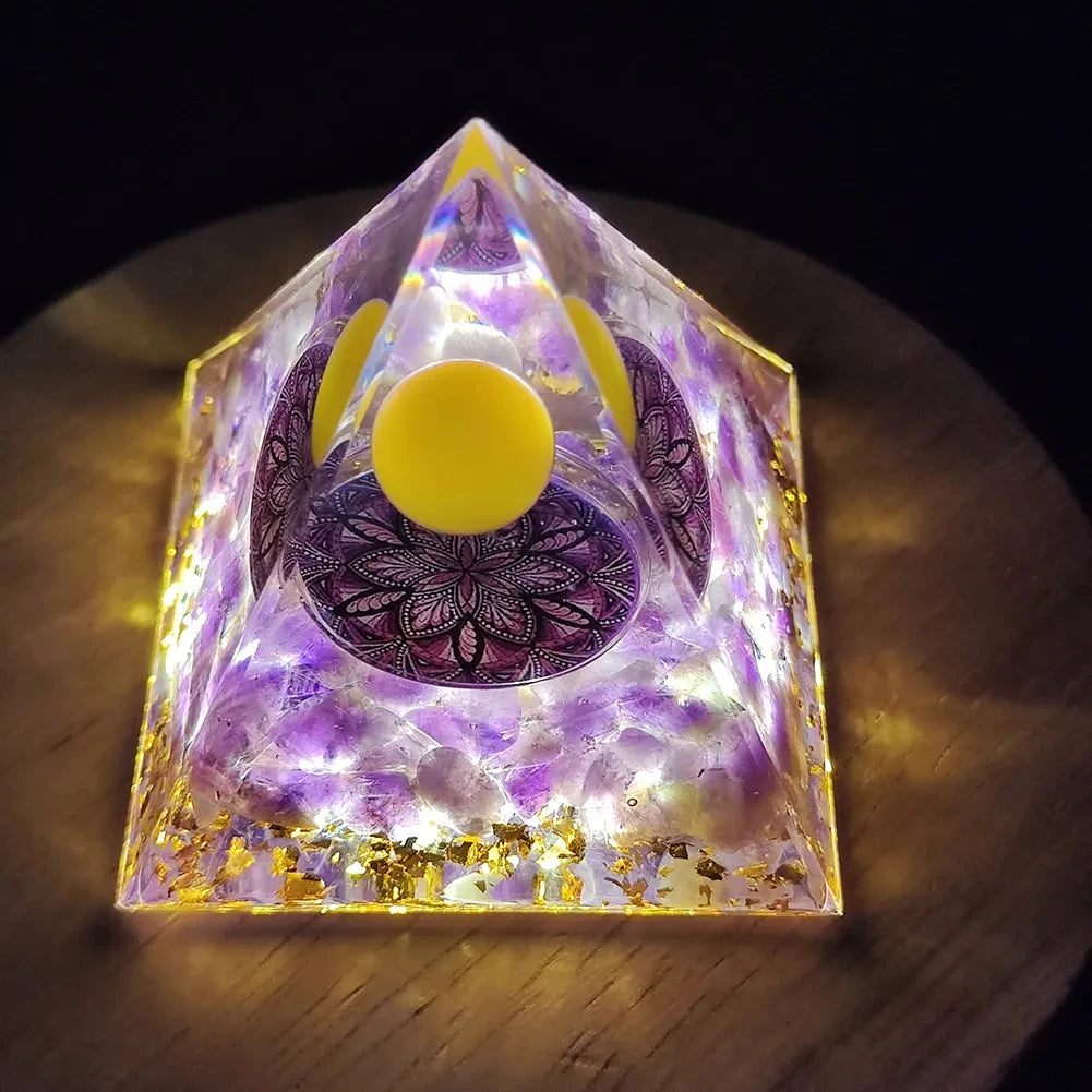 Pyramid-shaped crystal with purple and yellow colors on a wooden surface