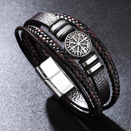 Bracelet with braided design and central emblem on a gray background