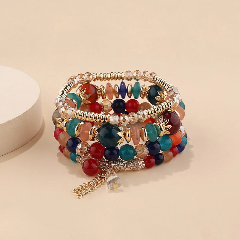 Multicolored beaded bracelet with gold accents on a beige background
