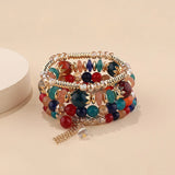 Multicolored beaded bracelet with gold accents on a beige background