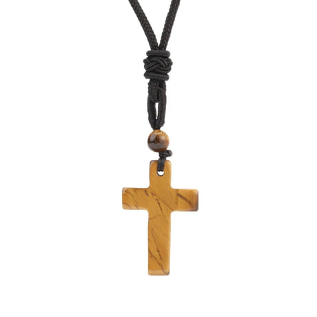 Wooden cross pendant on a black cord against a white background
