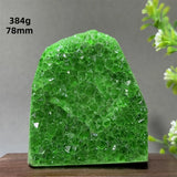 Green crystal rock on a wooden surface with a gray background