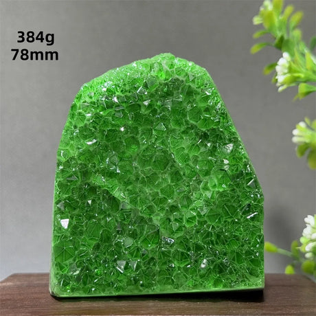 Green crystal rock on a wooden surface with a gray background