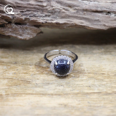 Silver ring with a blue gemstone on a wooden surface