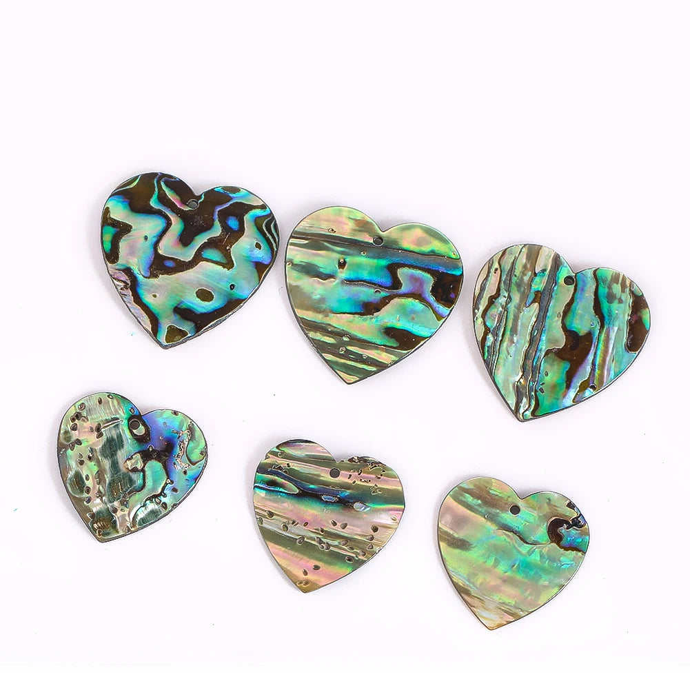 Set of six heart-shaped abalone shells on a white background