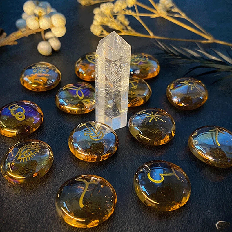 Crystal points and round amber-colored stones with engravings on a dark surface.