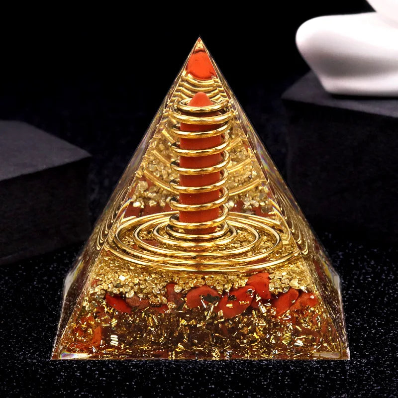 Pyramid-shaped object with gold and red elements on a dark surface