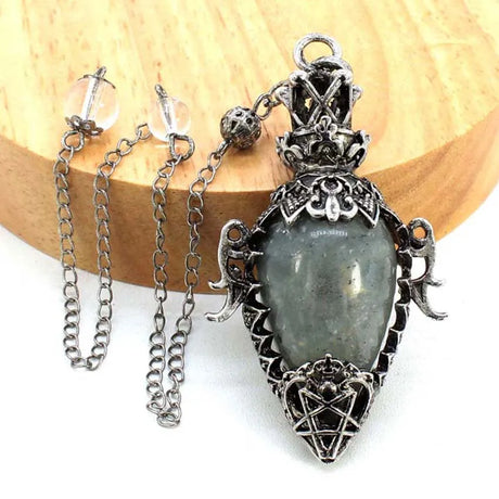 Silver pendant with a central stone on a wooden background