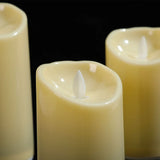 Three white candles with lit wicks against a black background