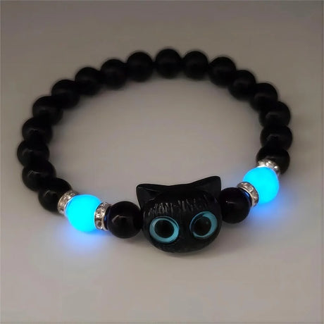 Black beaded bracelet with a cat-shaped charm and glowing blue beads on a light gray background