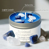 Blue candle in a tin labeled 'Spiritual Connection' with stones around it.