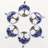 Set of six circular pendants with tree designs and blue flowers on a white background