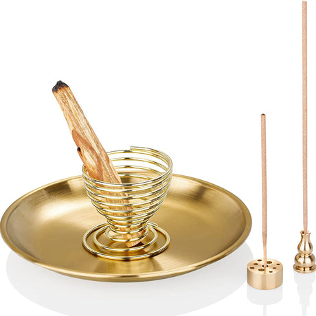 Gold incense burner with wooden stick and additional incense sticks on a white background