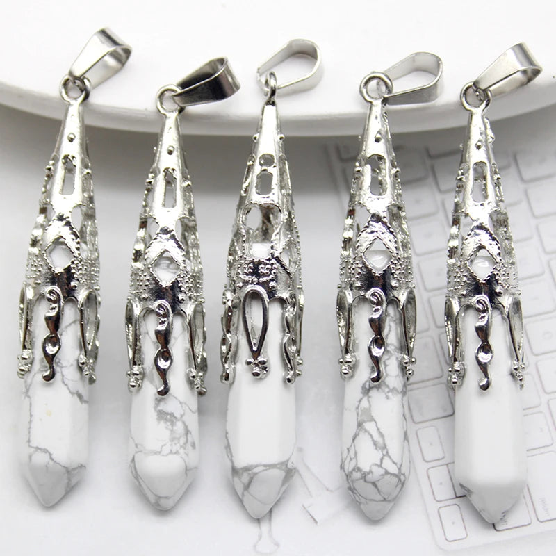 Five silver pendants with white stones on a white surface