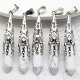 Five silver pendants with white stones on a white surface