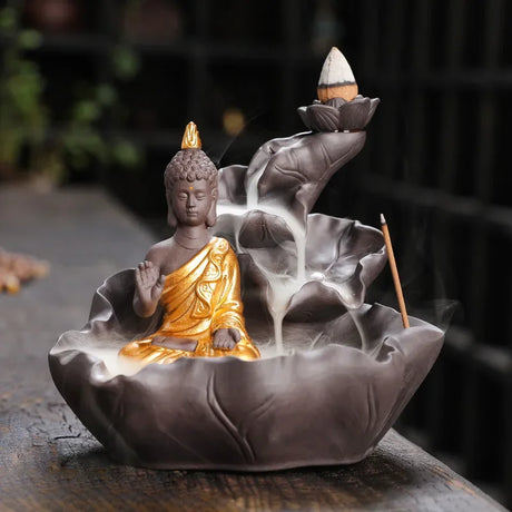 Incense burner with Buddha statue and incense sticks on a dark background