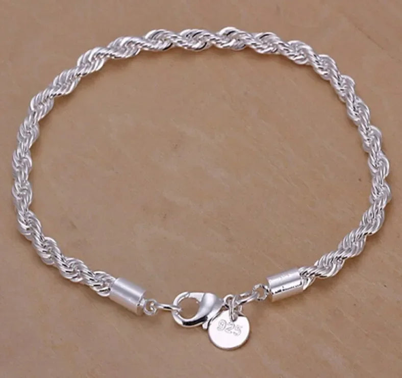 Silver braided bracelet with a clasp on a beige background
