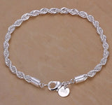 Silver braided bracelet with a clasp on a beige background