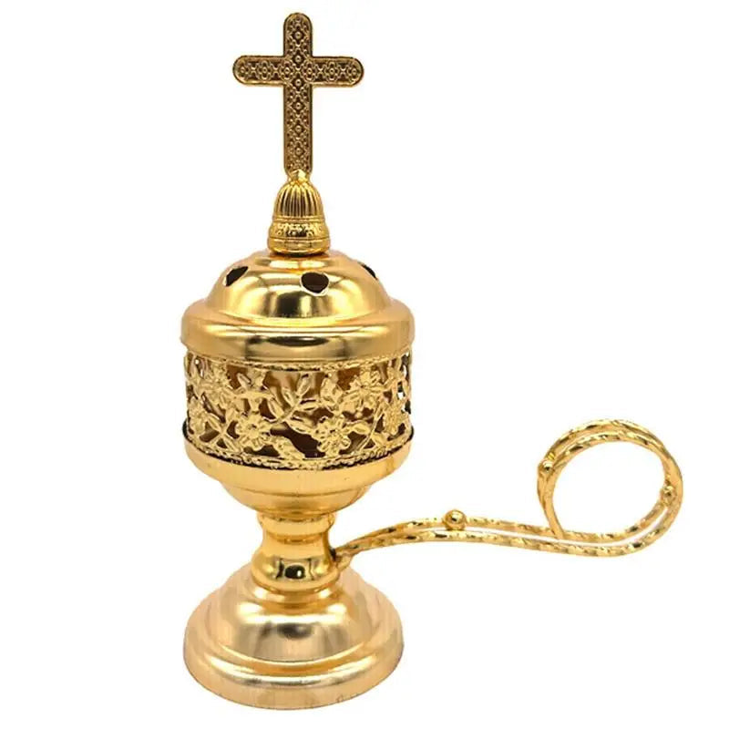 Gold incense burner with cross on top on a white background