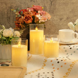 Candlelit table setting with flowers and a cup on a patterned tablecloth.