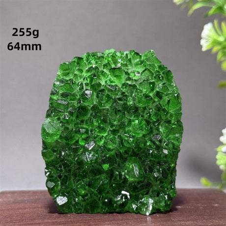 Green crystal rock on a wooden surface with a gray background