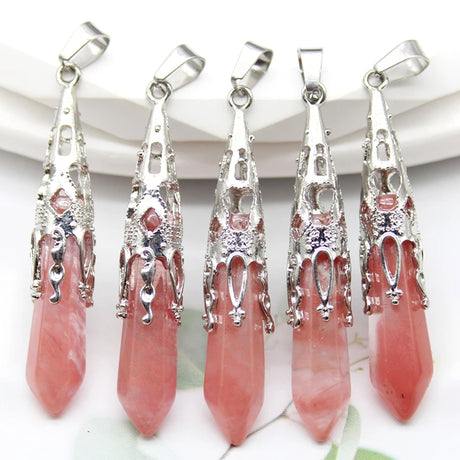 Five pink crystal pendants with silver tops on a white background