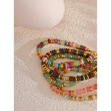 Set of colorful beaded bracelets on a textured surface