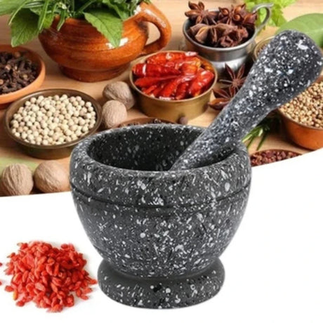 Mortar and pestle with various spices and herbs on a wooden surface