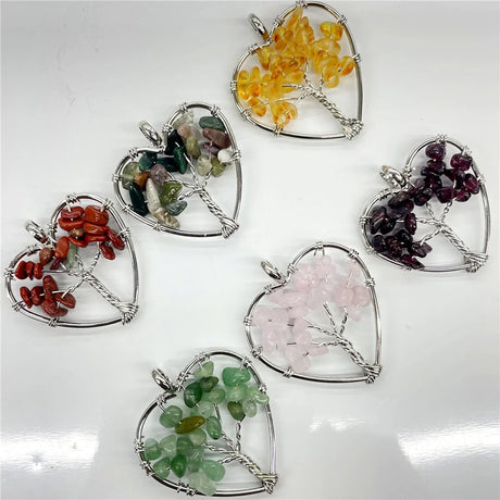 Heart-shaped pendants with various colored stones on a white background