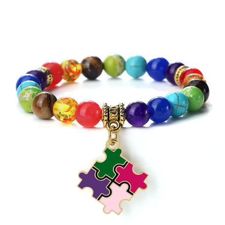 Colorful beaded bracelet with a puzzle piece charm on a white background