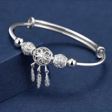 Silver bracelet with decorative beads on a blue background
