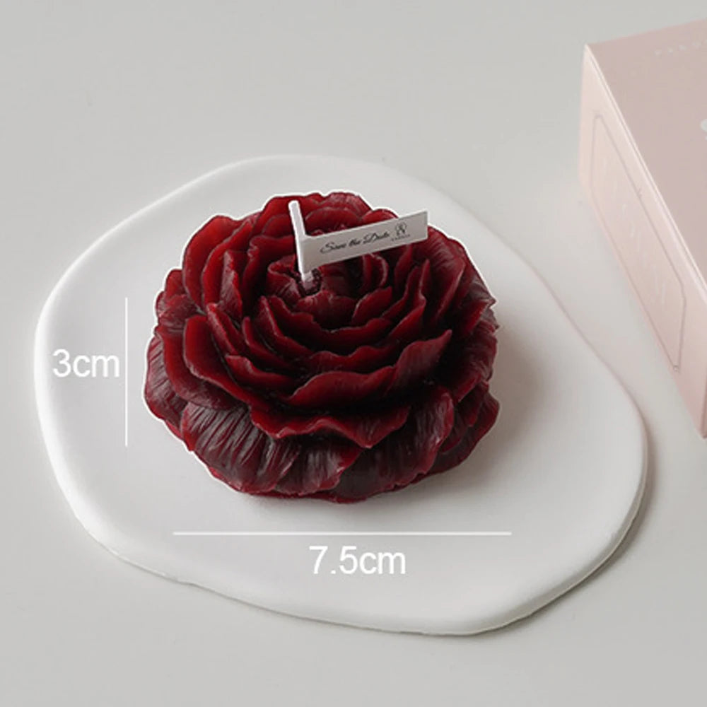 Red rose-shaped cake on a white plate with measurements and a brand name tag.