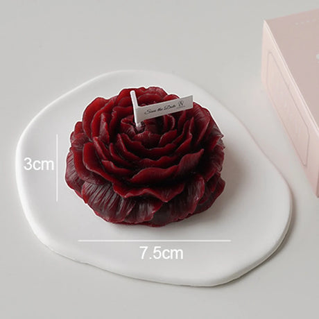 Red rose-shaped cake on a white plate with measurements and a brand name tag.